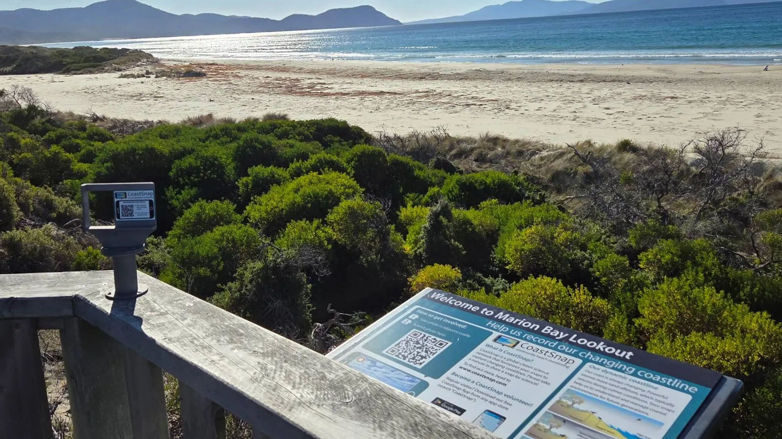 Marion Bay from the lookout: the beach and hills beyond a CoastSnap post and an interpretive sign about the changing coastline